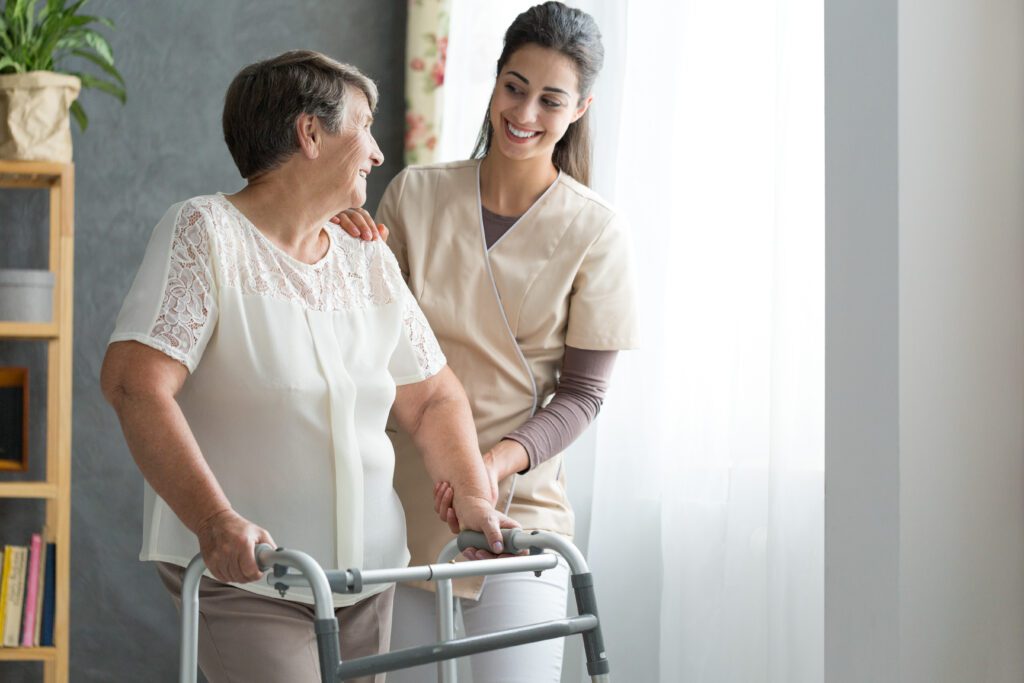 Smiling Nurse Helping Senior Lady to Walk Around